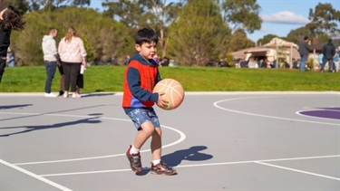 Boy plays with basketball at Yarralumla Reserve