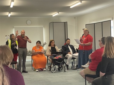 The-Peer-Action-group-sits-together-listening-attentively-to-a-speaker-reflecting-on-the-busy-year