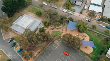 Drone image of car park, hall building, road and playground