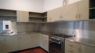 Large kitchen with benches, cupboards, sink and stove