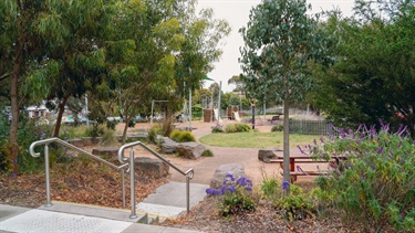 Outdoors image of steps, park bench and playground