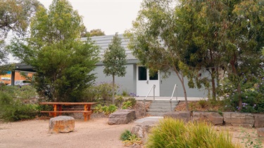 Front entrance to hall with table bench, trees and steps