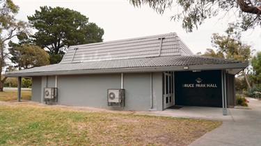Image of outside of hall with grey building and sign