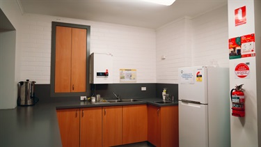 Kitchen with benches, cupboards and fridge